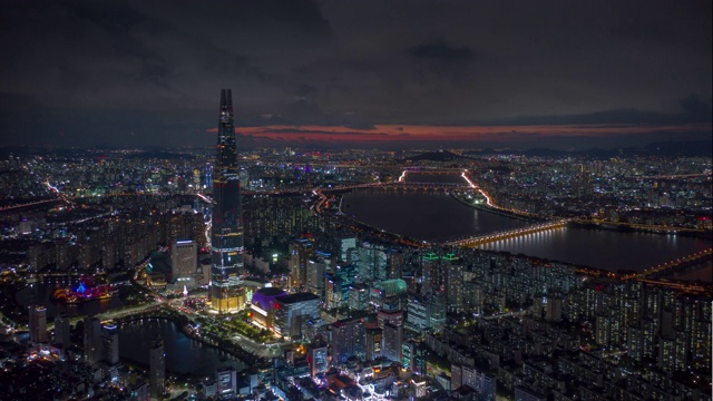 日落之夜照亮首尔城著名的塔滨江湾空中全景，4k时间跨度的韩国视频素材