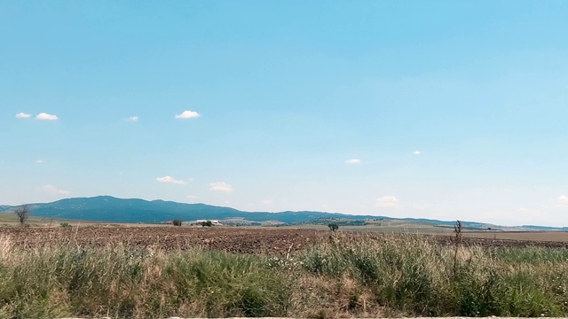 在田野和草地旁边的乡间小路上开车视频素材