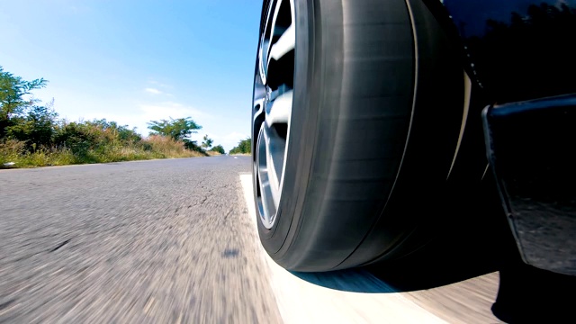 近距离观察汽车的轮胎在道路上快速旋转视频素材