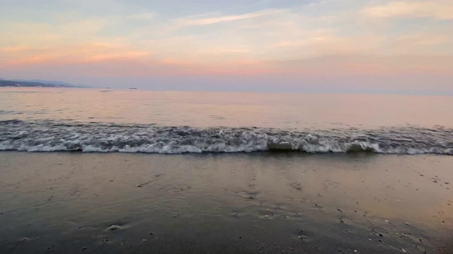 日落时海浪拍打着海滩视频素材