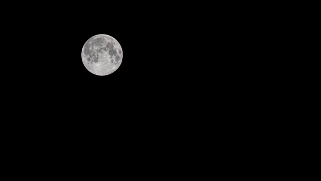 时间流逝:月亮漂浮在夜晚黑色的天空4K视频素材