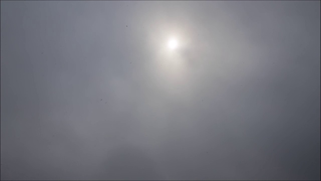 时间流逝:太阳穿过厚厚的、暴风雨般的乌云照耀着。4 k视频素材