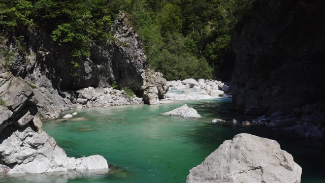 航拍移动后退峡谷的翠绿色高山河流索卡在山区，斯洛文尼亚视频素材