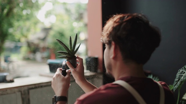 亚洲男子在家里给植物浇水视频素材