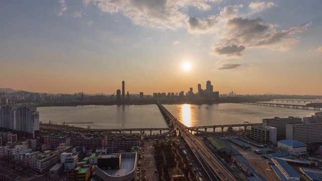 夕阳下，韩国首尔龙山谷，江边高速公路和汉江上的原孝大学桥上行驶的汽车视频素材