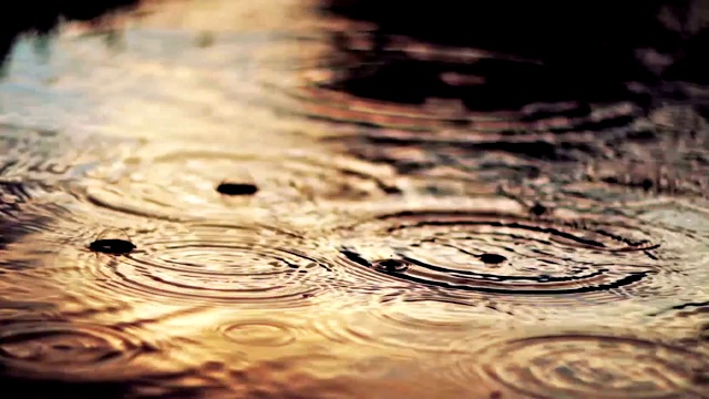 雨水落在水坑上。夕阳映照在水坑里视频素材