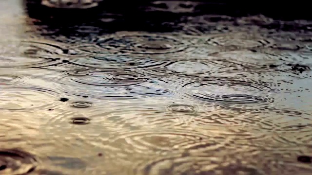 雨水落在水坑上。夕阳映照在水坑里视频素材