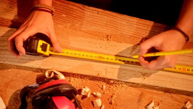 木匠测量木板的手的特写视频素材