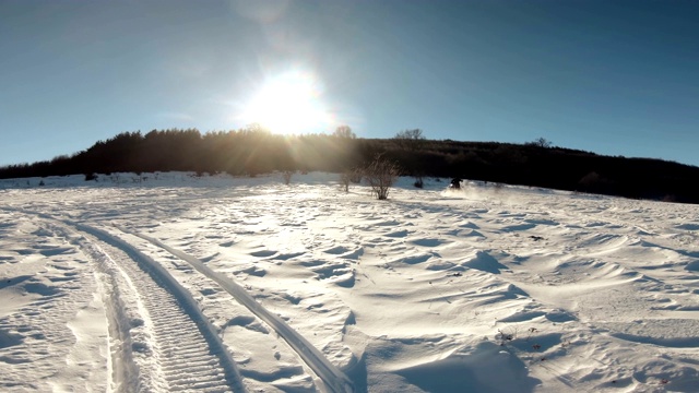 雪地摩托驾驶员在日出的阳光下加速跳跃视频素材