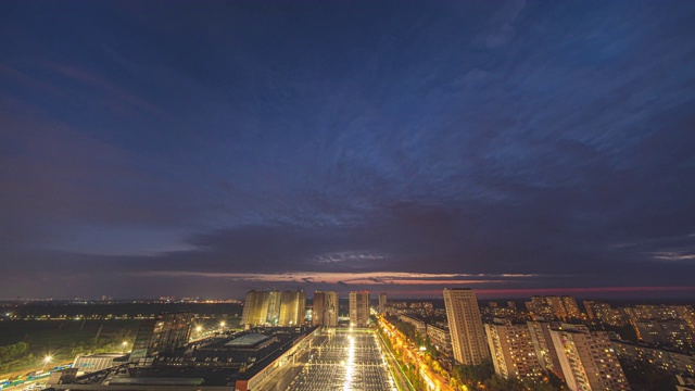 夜空的云朵掠过城市的灯光。时间流逝视频素材