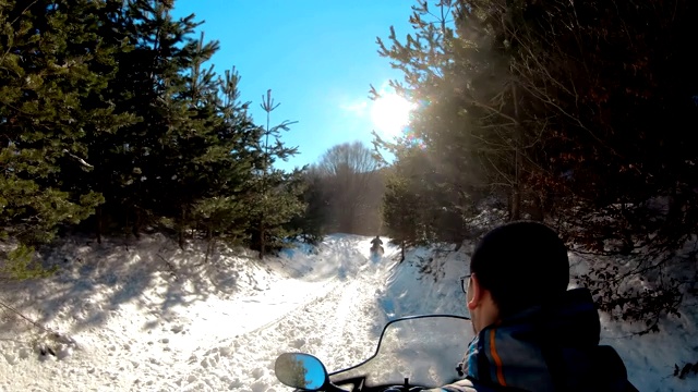 在冬季的山上，骑雪上摩托的人视频素材