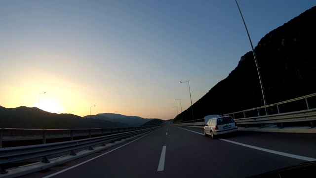 高速公路行驶，进入山区隧道和出口与惊人的日出，日落天空视频素材