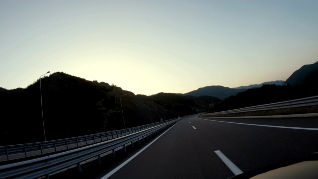 在高速公路隧道和出口行驶在日落，日出的天空视频素材