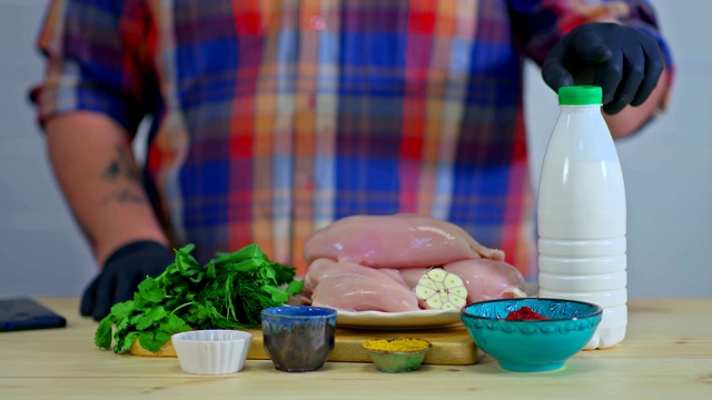 厨师展示他将在烹饪中使用的食材。肉、酱汁和香料都在桌子上。烹饪原料，特写。视频素材