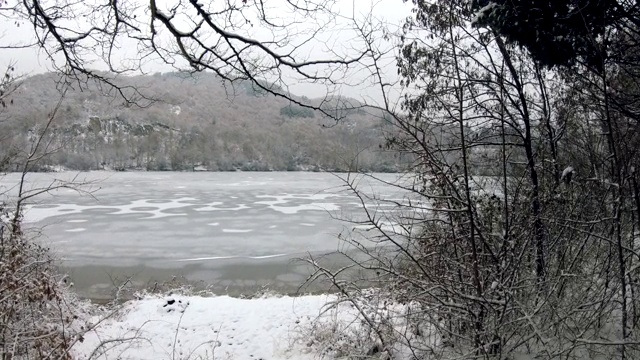 下雪的时候，树枝上结冰的湖面令人惊叹，冬天的风景视频素材