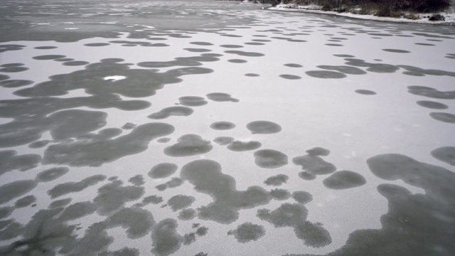 鸟瞰图的冬季积雪覆盖的森林和冰冻的湖泊视频素材