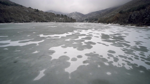 冰冻的湖泊和被雪覆盖的森林的鸟瞰图视频素材