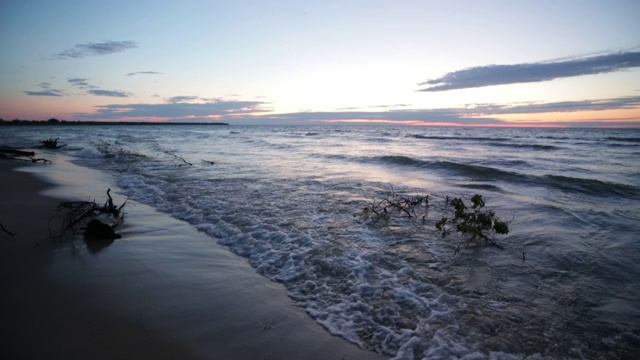 夏日日落时，海浪拍打着密歇根州休伦湖的海滩视频素材