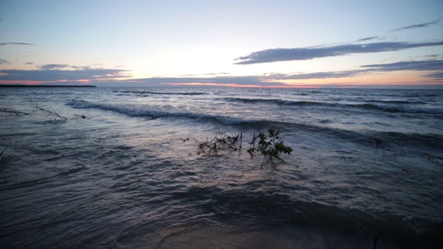 夏日日落时，海浪拍打着密歇根州休伦湖的海滩视频素材