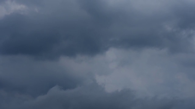 随着时间的推移，黑色的雨云在白天的天空中快速移动。视频素材