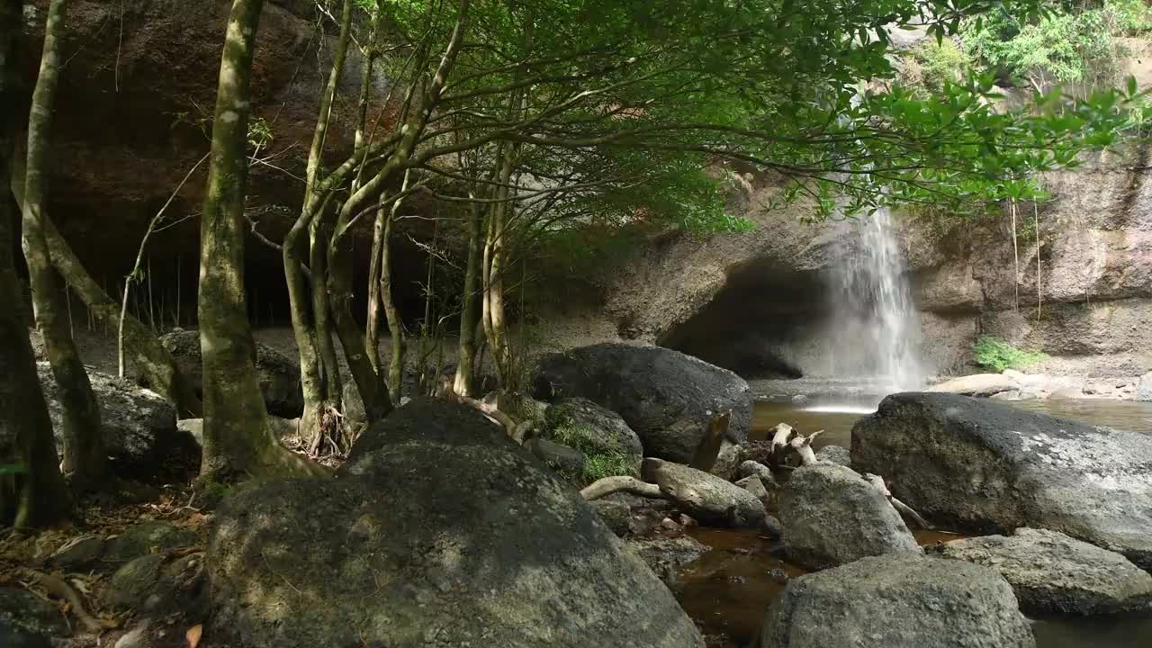 热带雨林中的瀑布。这个瀑布位于泰国国家公园的深山森林中。小溪的周围是由大树长成的绿色丛林。由护林员保护的森林。视频素材