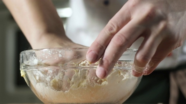 烹饪派。糕点师用手把黄油和面粉混合在一个杯子里。视频素材