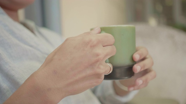 女孩喝咖啡或茶，享受坐在家里。早上第一件事就是去做。视频素材