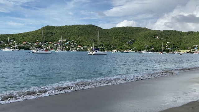 平静的海水拍打着海滩，停泊的游艇，伊丽莎白港，Bequia，圣文森特和格林纳丁斯，西印度群岛，加勒比，中美洲视频素材