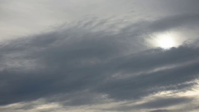 随着时间的推移，黑色的雨云在天空中快速移动，傍晚，太阳被云遮住了。视频素材