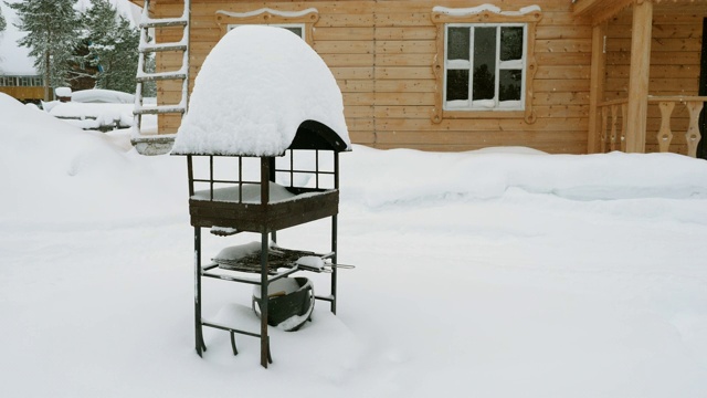 在下雪的冬天，站在木屋前的烤肉架或火盆。视频素材