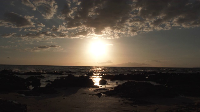 海滩景象，太阳低在海洋地平线上视频素材