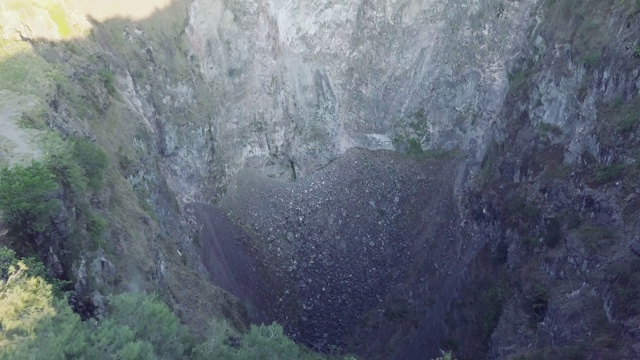 一个深和干燥的火山洞鸟瞰图与岩石滑坡在山上视频素材