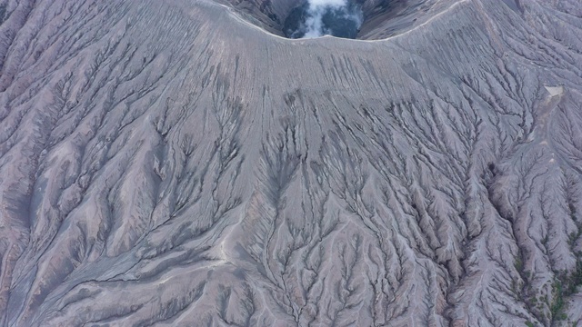 从上面俯瞰，令人惊叹的布罗莫火山鸟瞰图和从火山口升起的气体云。视频素材