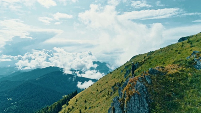 这个人站在山崖上，看到美丽的风景视频素材