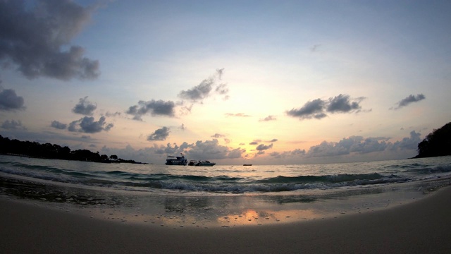 时间流逝的运动，海浪击中海滩和船背景云移动快，金色的光日出在早晨的天空视频下载