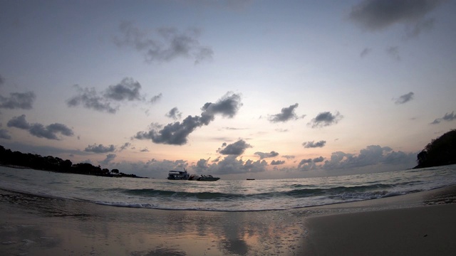 时间流逝的运动，海浪击中海滩和船背景云移动快，金色的光日出在早晨的天空视频下载