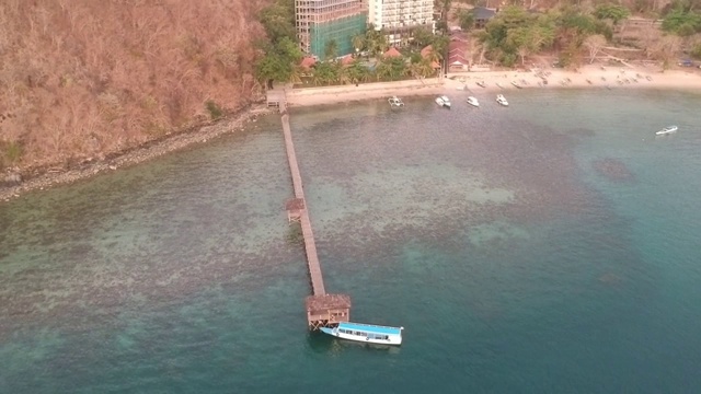 日落时分，无人机拍摄的海滩和港口。船只和码头，平静的海洋和岛屿，纳闽巴霍印度尼西亚视频素材