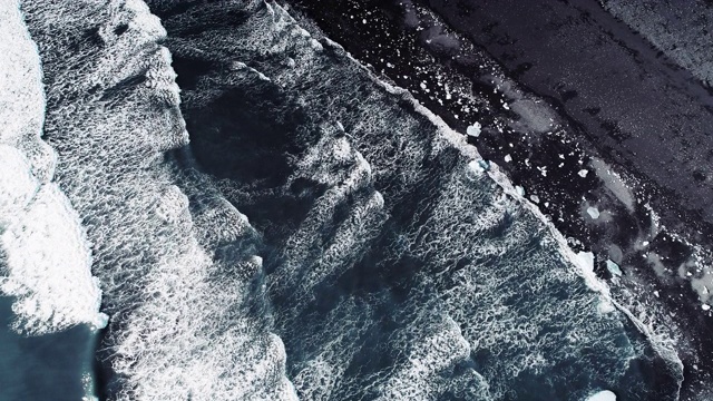 在冰岛Jokulsarlon钻石海滩上俯瞰海浪冲刷海岸的航拍照片视频素材