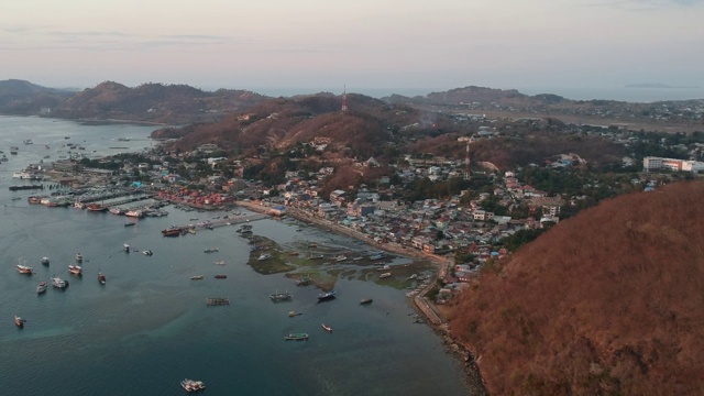 日落时分，无人机拍摄的海滩和港口。船只和码头，平静的海洋和岛屿，纳闽巴霍印度尼西亚视频素材