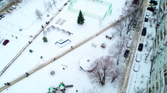 人们沿着积雪的院子走在住宅楼之间视频素材