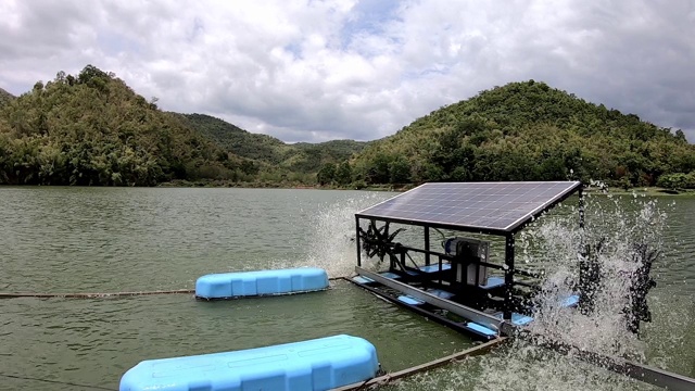 水轮机是一种工作轮转，造成了氧水疗法在水库背景下的山和天空中的云。视频素材