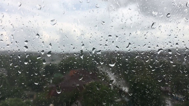 雨敲打着窗户玻璃，暴雨，雨季，悲伤，放松。忧郁，在雨天呆在屋里视频素材