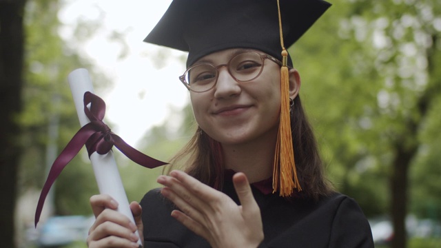 穿着毕业礼服和学位帽的少女视频素材