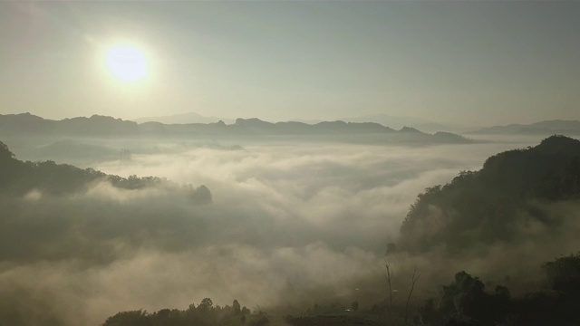 鸟瞰图的雾滚过流动在泰国北部的雨林山视频素材