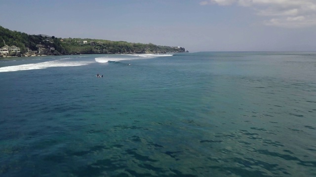 在热带海洋上空飞行，海浪和冲浪者在水中游泳视频素材