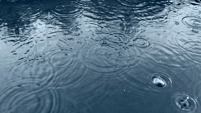 雨后形成大水坑，水珠在水面上形成圆圈视频素材