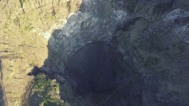 一个深和干燥的火山洞鸟瞰图与岩石滑坡在山上视频素材