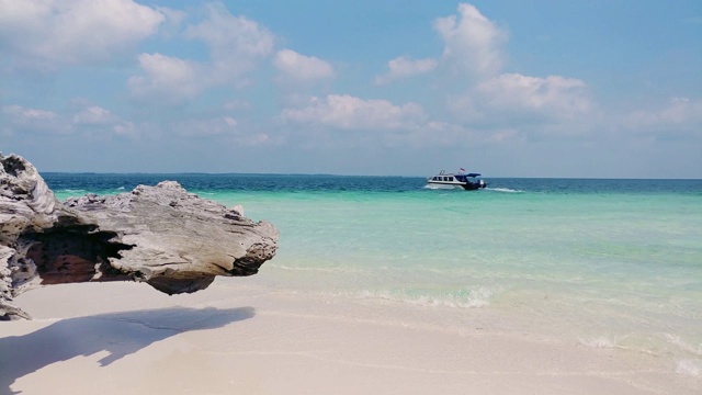 美丽的海滩，清澈纯净的蓝绿色的水，白色的沙子，温和的海浪，和一个树干在屏幕的左侧视频素材