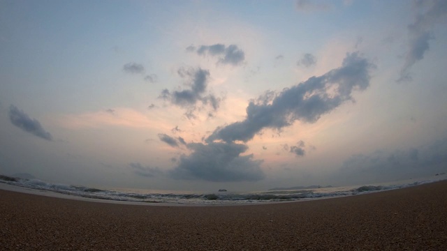 时间流逝的运动，海浪击中海滩和船背景云移动快，金色的光日出在早晨的天空视频素材