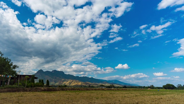 稻田对蓝天与山的背景，时间流逝视频视频素材